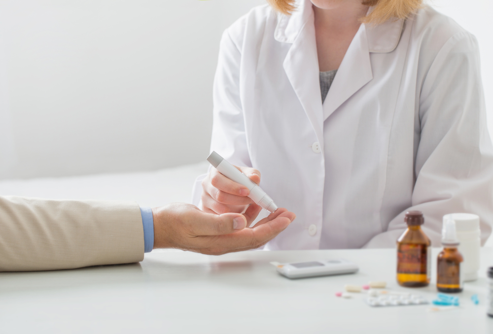 Doctor measures the blood sugar level of the patient